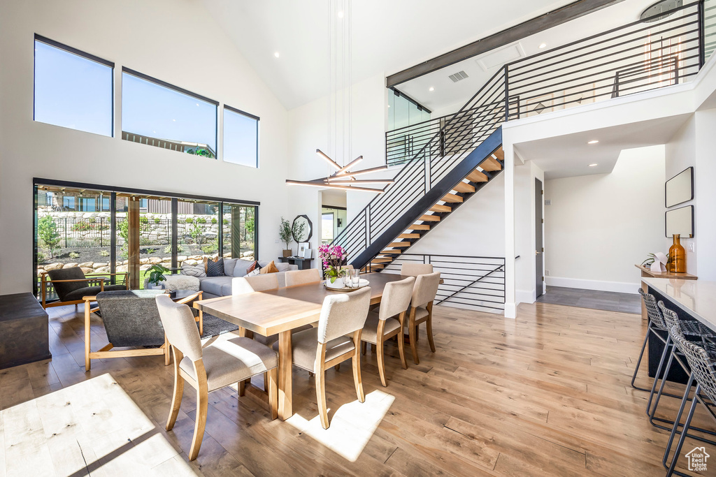 Dining room featuring hardwood / wood-style floors, a high ceiling, and a chandelier