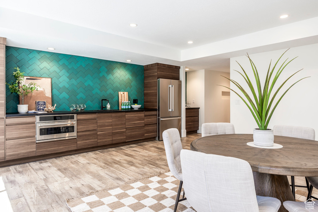 Dining space with light hardwood / wood-style flooring and sink