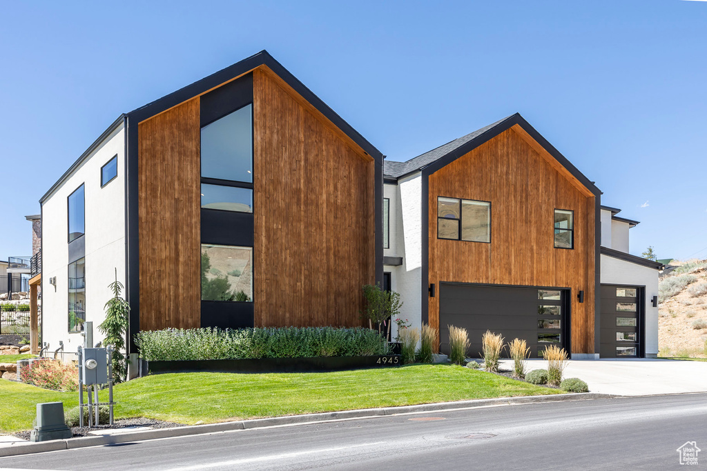 Modern home with a front yard and a garage