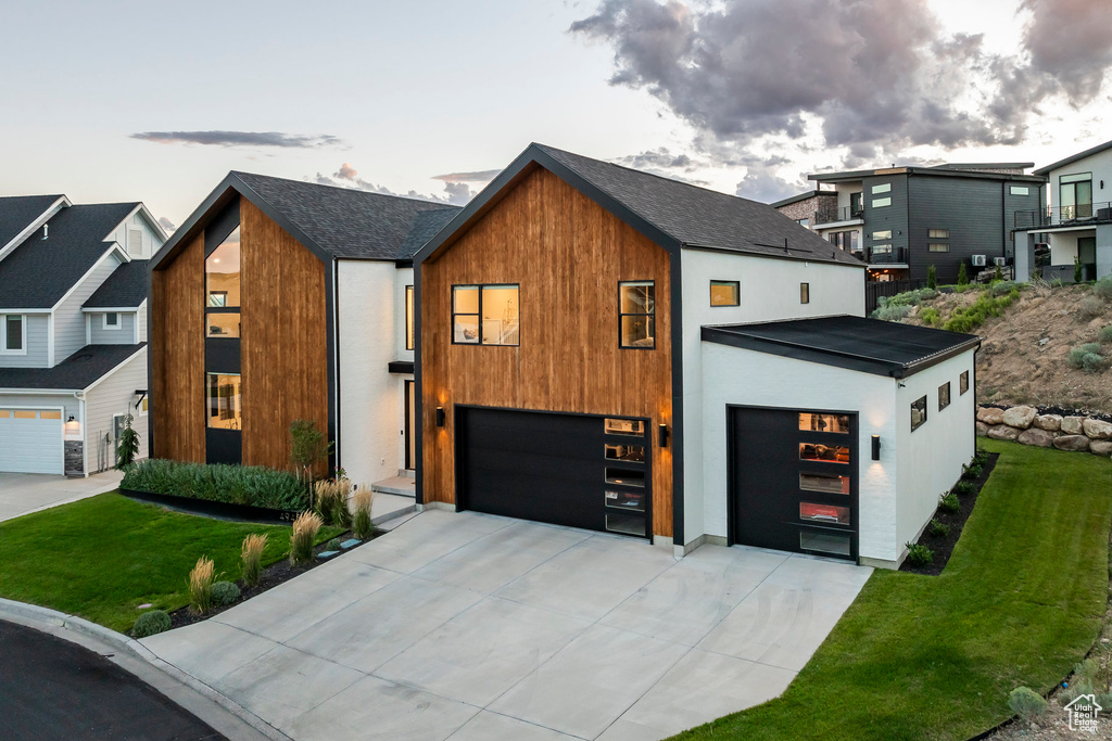 Contemporary house featuring a front yard and a garage