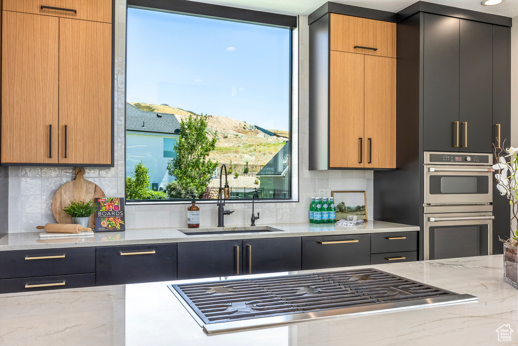 Kitchen with light stone countertops, sink, stainless steel appliances, and a mountain view