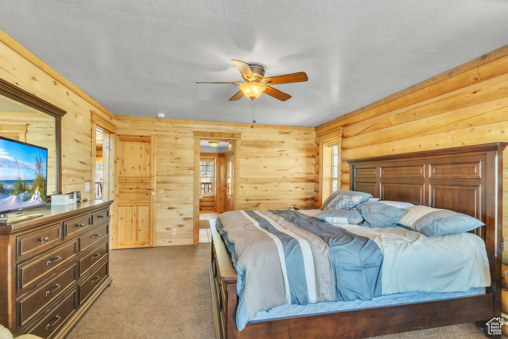 Carpeted bedroom with ceiling fan and a textured ceiling