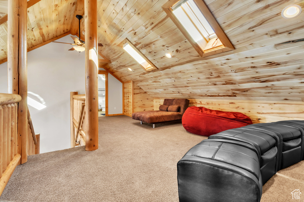 Bonus room featuring vaulted ceiling with skylight, ceiling fan, wooden ceiling, and carpet floors