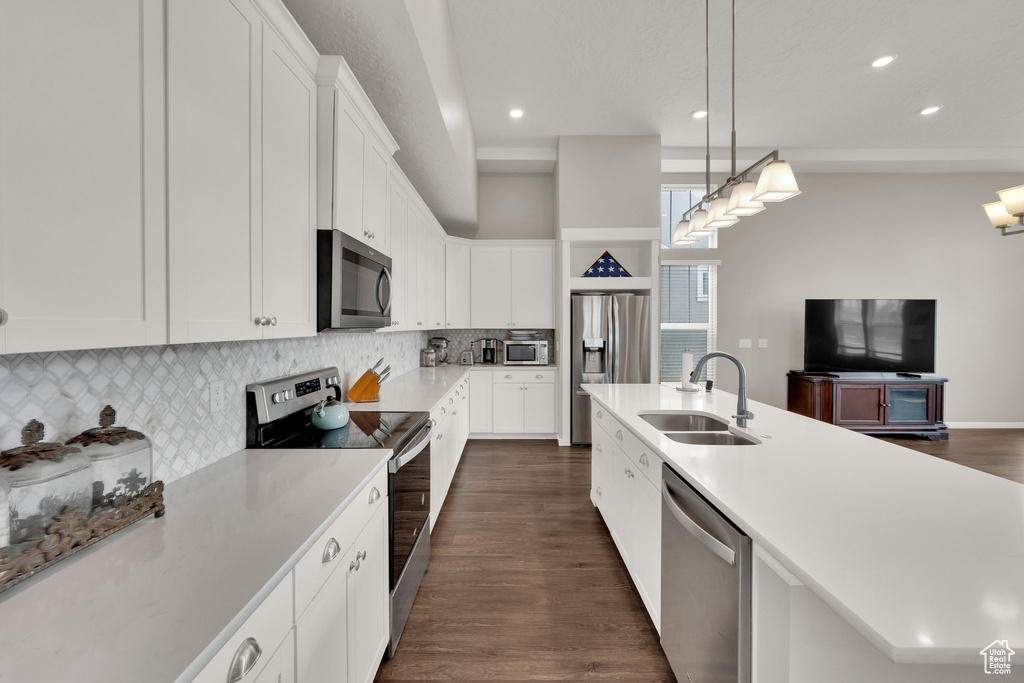 Kitchen featuring appliances with stainless steel finishes, a sink, recessed lighting, light countertops, and backsplash
