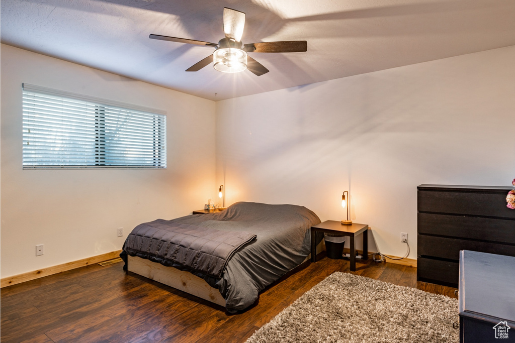 Bedroom featuring ceiling fan and dark hardwood / wood-style flooring