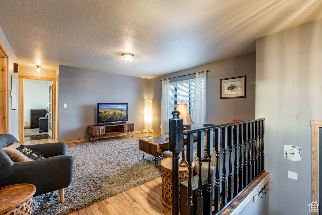 Living room with a textured ceiling and hardwood / wood-style flooring