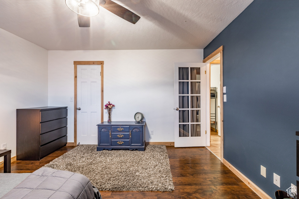 Bedroom featuring ceiling fan, dark hardwood / wood-style flooring, and a textured ceiling