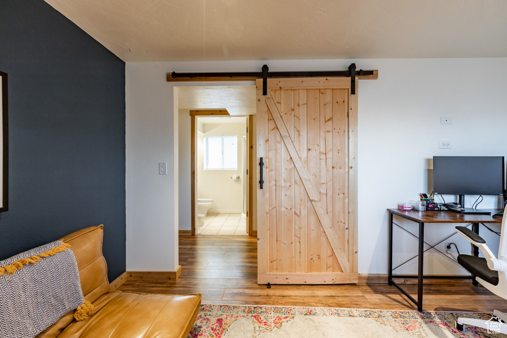 Office area featuring a barn door and wood-type flooring