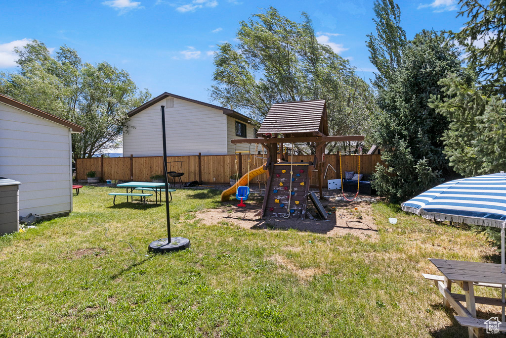 View of jungle gym with a lawn and a trampoline