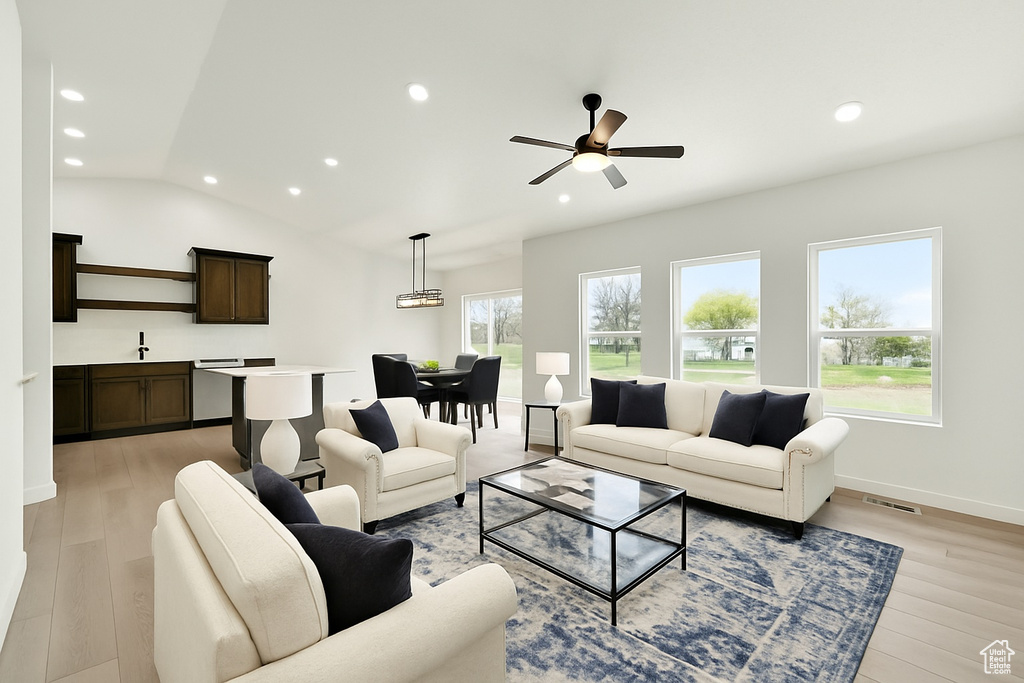 Living room with recessed lighting, a wealth of natural light, and light wood-type flooring
