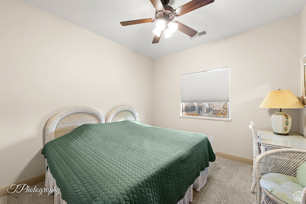 Carpeted bedroom featuring ceiling fan