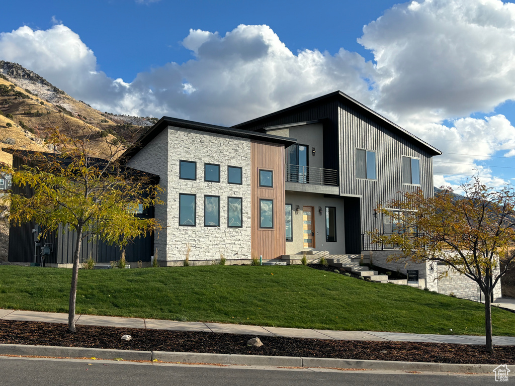 Contemporary home with a balcony and a front yard