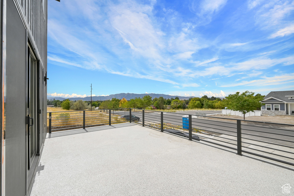 View of patio featuring a balcony and a mountain view