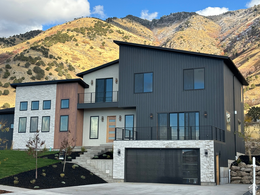 View of front of house featuring a balcony, a garage, and a mountain view