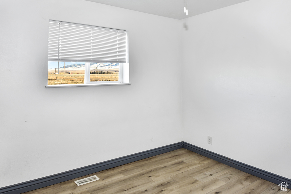 Empty room with hardwood / wood-style flooring