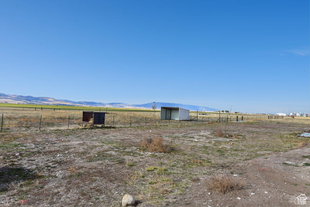 View of yard featuring a rural view, a mountain view, and an outbuilding