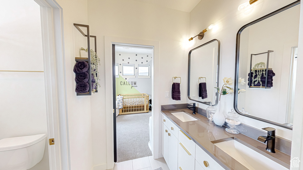 Bathroom featuring toilet, vanity, and tile patterned floors