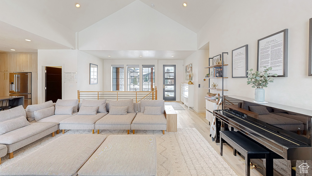 Living room featuring high vaulted ceiling and light hardwood / wood-style flooring