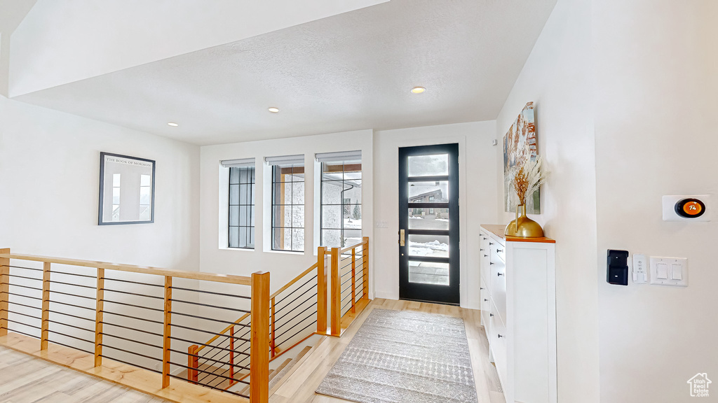 Entrance foyer featuring a textured ceiling and light hardwood / wood-style floors