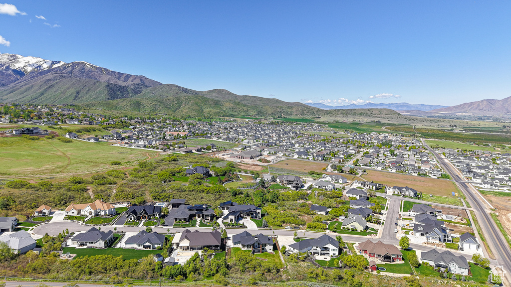 Aerial view of property and surrounding area with nearby suburban area and mountains