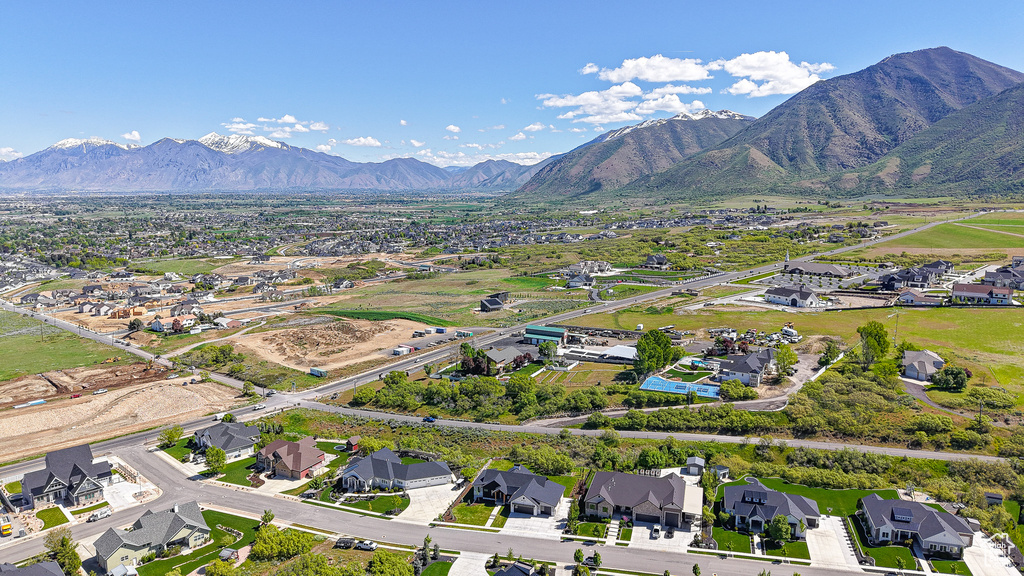 Aerial view of property and surrounding area featuring nearby suburban area and mountains