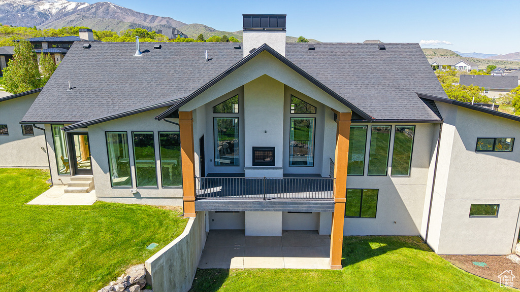 Rear view of property featuring a chimney, stucco siding, and a mountain view
