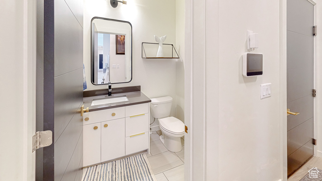 Bathroom featuring toilet, vanity, and tile patterned flooring