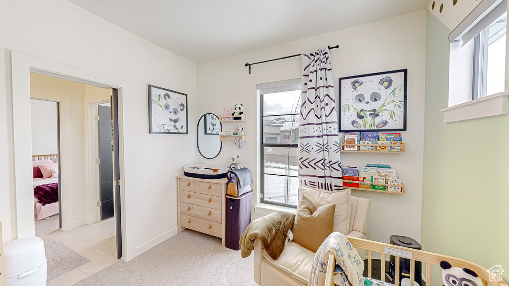 Bedroom featuring light colored carpet and multiple windows