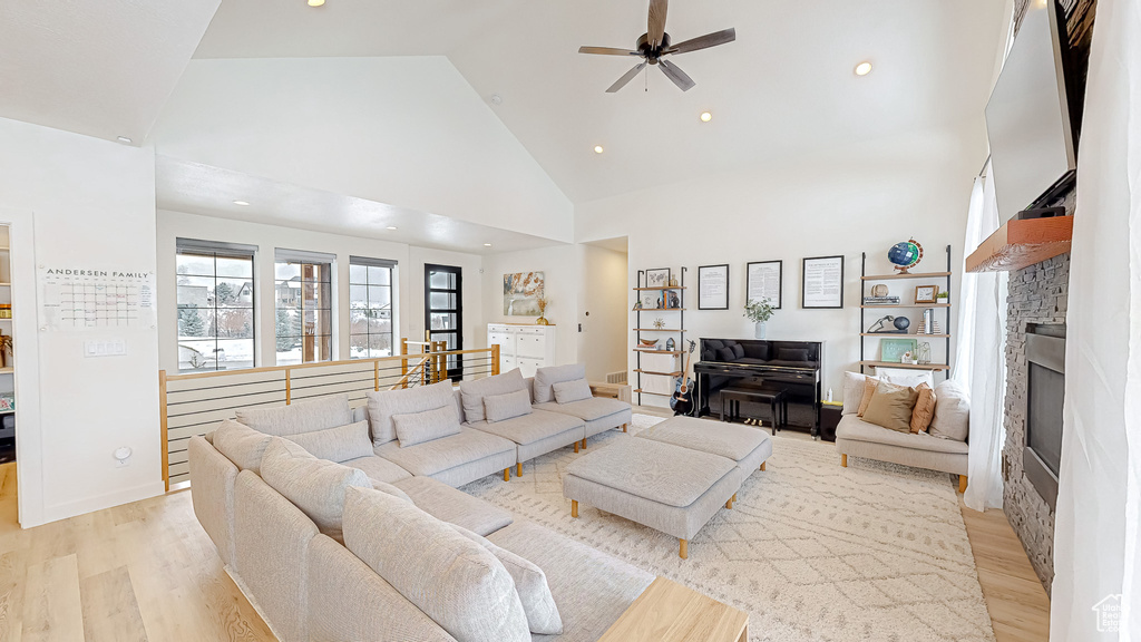 Living room featuring ceiling fan, light hardwood / wood-style flooring, and high vaulted ceiling