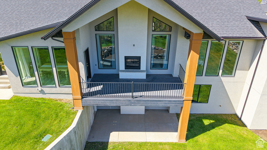 View of home's exterior featuring stucco siding, a shingled roof, and a yard