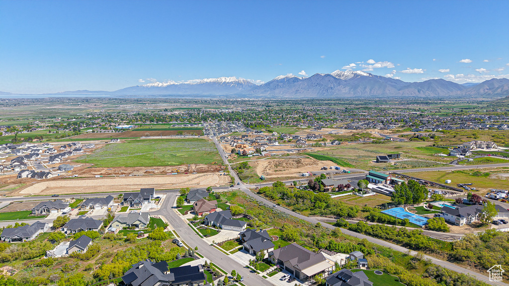 Aerial view of property and surrounding area with mountains and nearby suburban area
