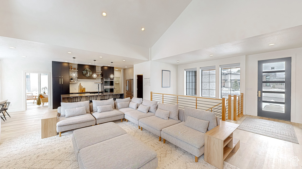 Living room featuring light hardwood / wood-style flooring and high vaulted ceiling