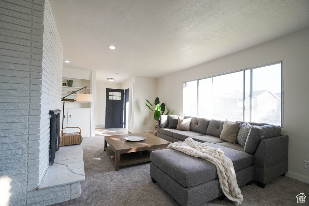 Living room with a brick fireplace and carpet floors