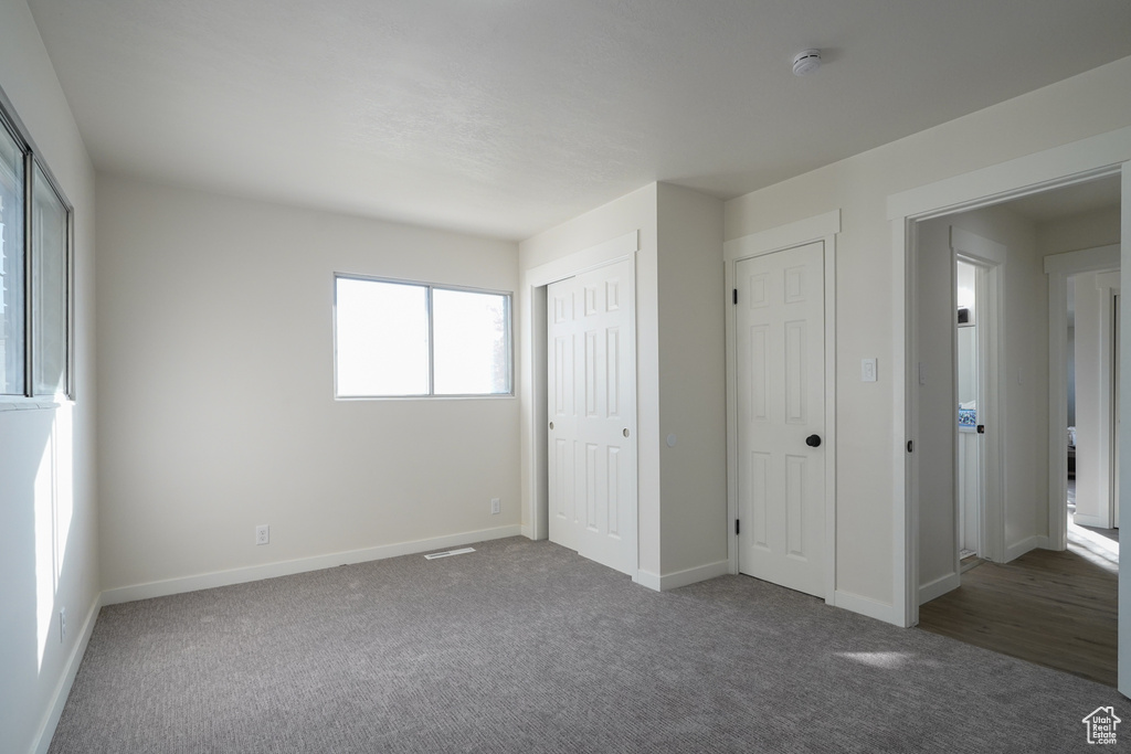 Unfurnished bedroom featuring dark colored carpet