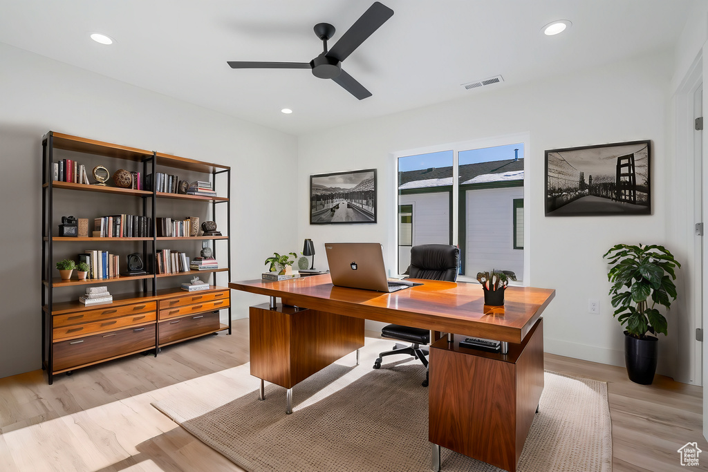 Home office featuring ceiling fan and light hardwood / wood-style floors