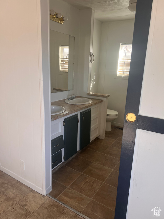 Bathroom with vanity, plenty of natural light, and toilet