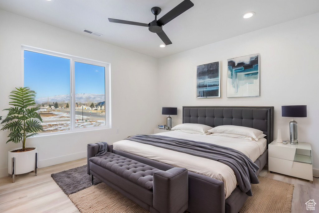 Bedroom featuring ceiling fan, light hardwood / wood-style floors, and a mountain view