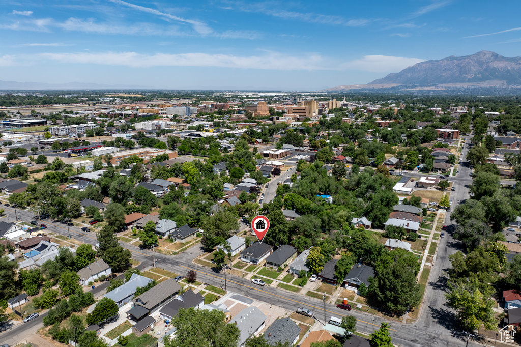 Aerial view of property and surrounding area with mountains and nearby suburban area