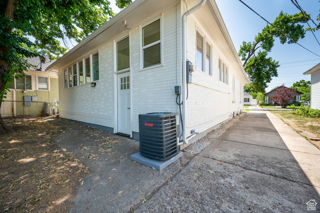 View of property exterior with brick siding and a cooling unit