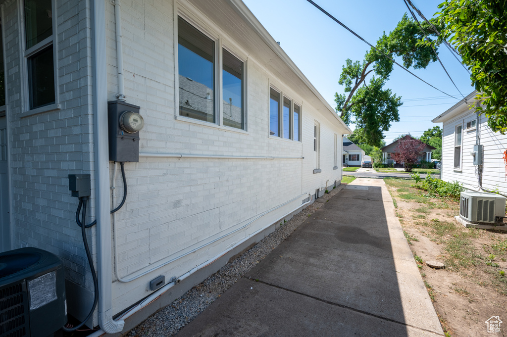 View of property exterior featuring brick siding and a central air condition unit