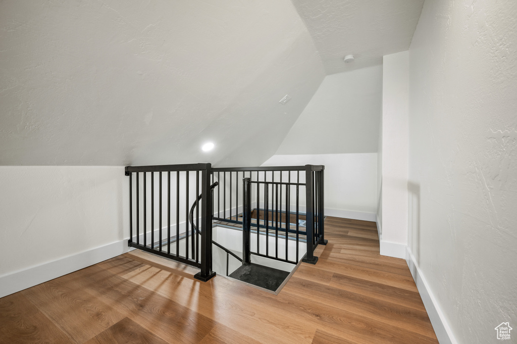 Staircase with lofted ceiling and wood finished floors