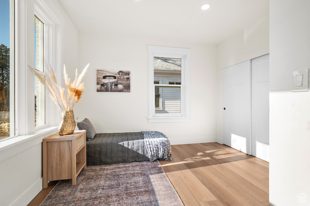 Bedroom with wood finished floors, recessed lighting, and a closet