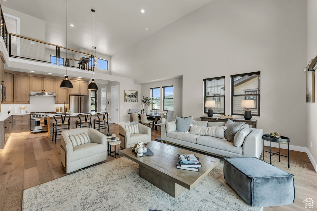 Living room with light wood-type flooring and a towering ceiling