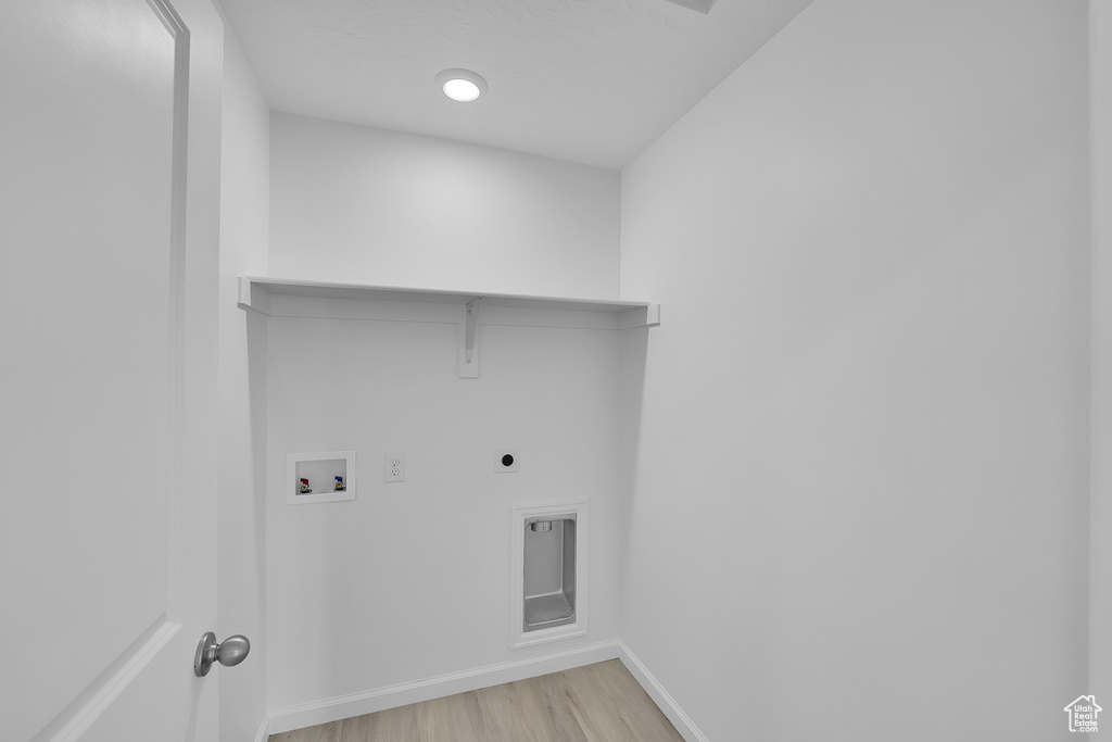 Washroom featuring hookup for a washing machine, baseboards, light wood-type flooring, and hookup for an electric dryer