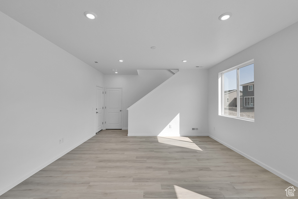 Unfurnished living room featuring recessed lighting, baseboards, and light wood-style flooring