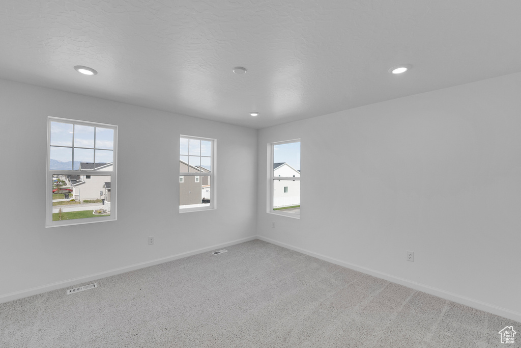 Carpeted empty room with baseboards and recessed lighting