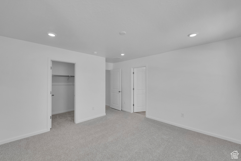 Unfurnished bedroom featuring carpet floors, recessed lighting, baseboards, and a spacious closet