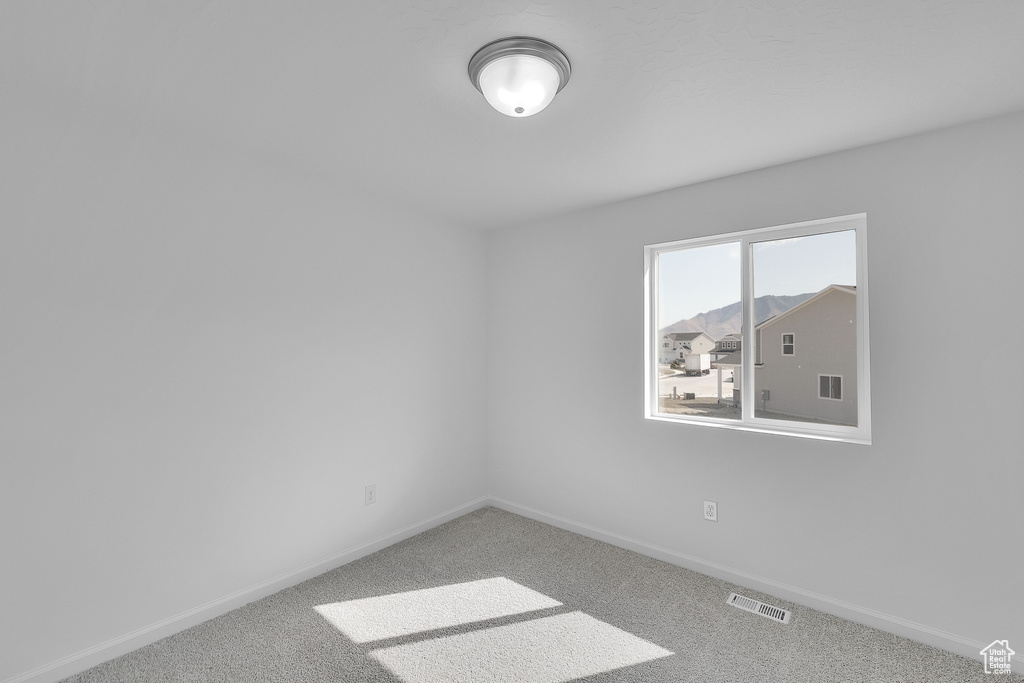 Spare room featuring baseboards and carpet flooring