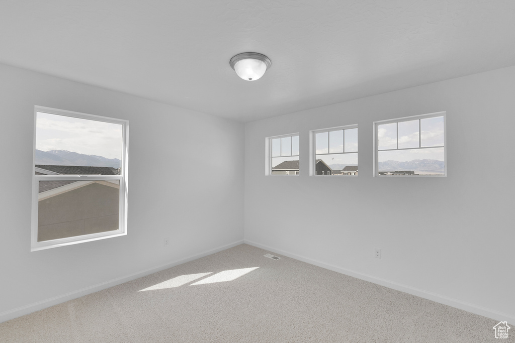 Carpeted empty room featuring baseboards