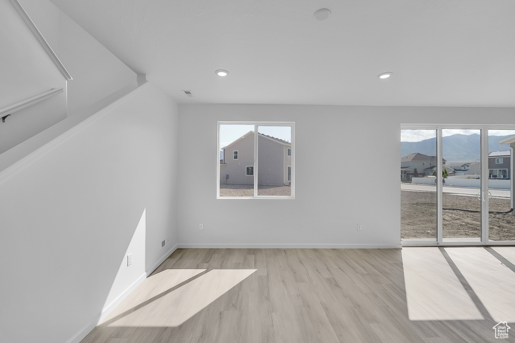 Spare room featuring wood finished floors, healthy amount of natural light, recessed lighting, baseboards, and a mountain view